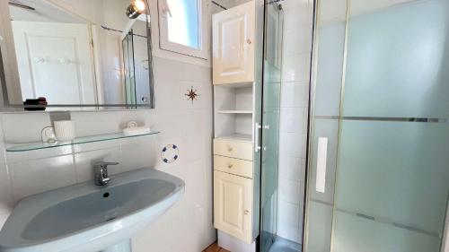 a bathroom with a sink and a glass shower at Charmante location de plain-pied proche plage in La Couarde-sur-Mer