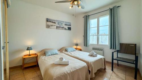 a bedroom with a bed and a chair and a window at Charmante location de plain-pied proche plage in La Couarde-sur-Mer