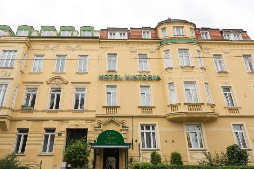 a large building with a large clock on the front of it at Hotel Viktoria Schönbrunn in Vienna