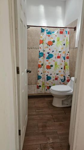 een badkamer met toilet en douchegordijn bij Villas Campos Monterrico in El Banco