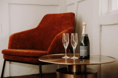 eine Flasche Wein und zwei Weingläser auf einem Tisch in der Unterkunft Bryggjan Boutique Hotel in Akureyri