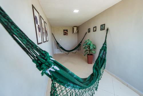 a room with two hammocks in a room at Casa em Jacuma, com piscina, 5 suites e fliperama in Jacumã