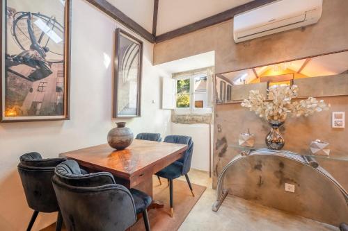 a dining room with a wooden table and chairs at GuestReady - Classic prestige in Costa da Caparica in Porto Brandão