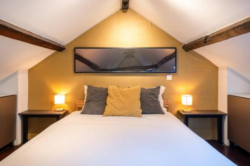 a bedroom with a bed with a flat screen tv on the wall at GuestReady - Classic prestige in Costa da Caparica in Porto Brandão