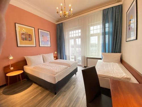 Una habitación de hotel con dos camas y una ventana. en Hotel Kronprinz Hamburg Hauptbahnhof, en Hamburgo