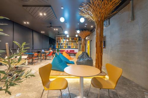 a room with a table and chairs and a couch at Patong Poshtel in Patong Beach