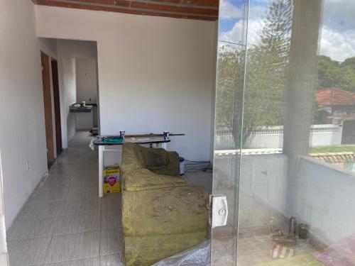 a living room with a couch and a glass wall at Casa Praia do Gaviao in Araruama