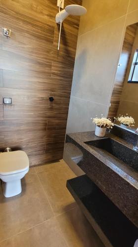 a bathroom with a toilet and stairs with flowers at MicroCasa em Capitólio-MG com Ar Condicionado in Capitólio