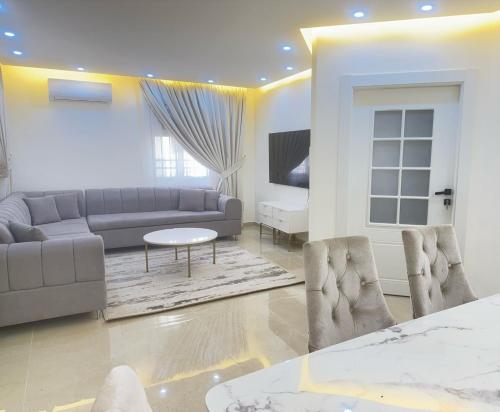 a living room with a couch and a table at Luxury Family Apartment With Balcony in Amman