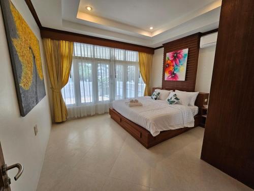 een slaapkamer met een bed en een groot raam bij Choeng Mon Bliss villa, pool private in Choeng Mon Beach