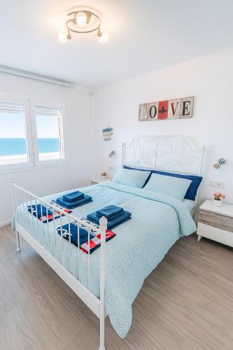 a white bedroom with a bed with blue pillows at Brisa Marina by Maja FTV Ocean View in Antigua
