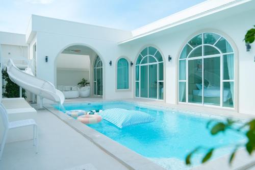 a swimming pool with a slide in a house at White Heaven Pool Villa Pattaya in Ban Huai Yai