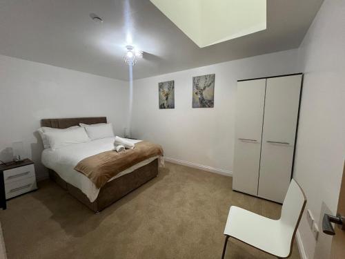 Stylish 2 bed Duplex Apartment - Birmingham في برمنغهام: غرفة نوم بها سرير وكرسي