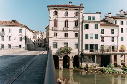 ヴィチェンツァにあるPalladio Apartment - Vista Fiume, In Centro con Garageの建物が立ち並ぶ都市の川にかかる橋