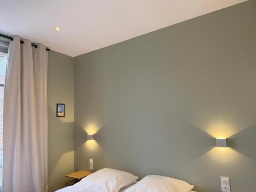 - une chambre avec deux lits et deux lumières sur le mur dans l'établissement Charmant appartement en centre-ville, à Le Touquet-Paris-Plage