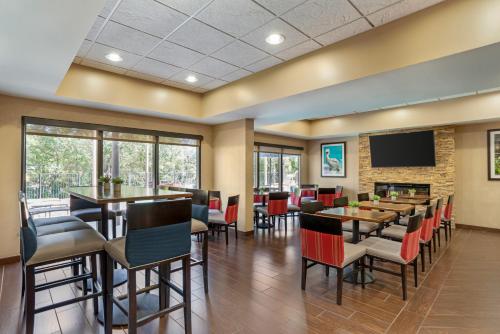 a restaurant with tables and chairs and a flat screen tv at Comfort Suites Tallahassee Capitol - University Area in Tallahassee