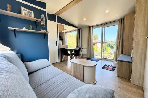 un salon avec un canapé et une table dans l'établissement Bungalow & caravane vintage proche plages, à Ploemeur