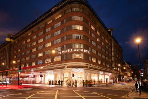 a large building on a city street at night at The Marble Arch Hotel, by Thistle in London