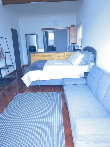 a bedroom with a bed and a couch at Jo-Anne Villa #Jeffreys Bay in Jeffreys Bay