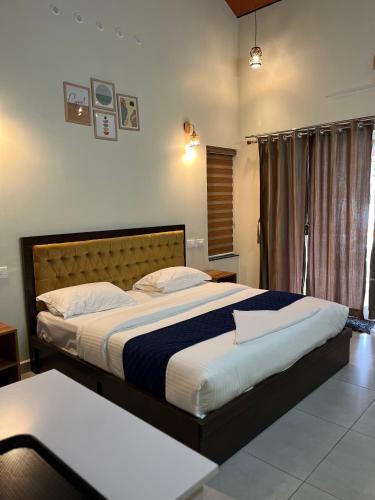 a bedroom with a large bed and a window at The VARANDAH LOUNGE 2BHK PRIVATE POOL VILLA VAGAMON in Vagamon