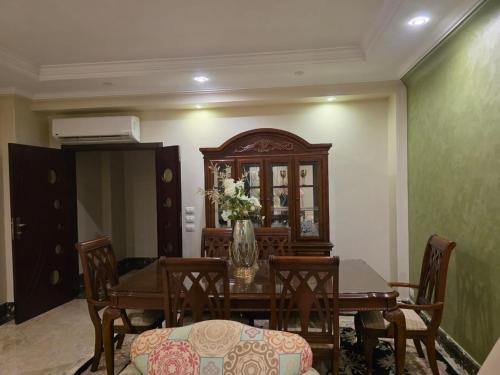 a dining room with a table with a vase of flowers at South B Paradise in Cairo