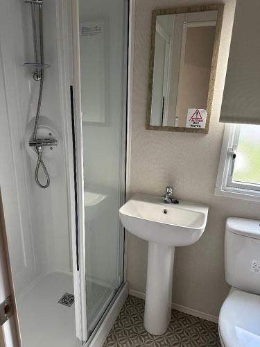 a bathroom with a sink and a shower and a toilet at Aurora Sky in Lossiemouth