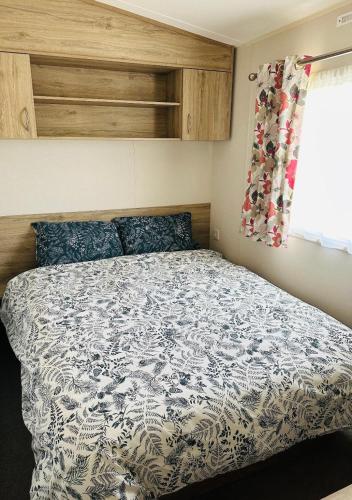 a bedroom with a bed with a blue and white comforter at Aurora Sky in Lossiemouth