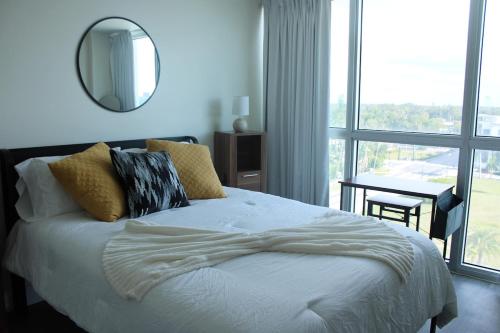 a bedroom with a bed with a mirror and a window at Oasis in the heart of Fort Myers in Fort Myers