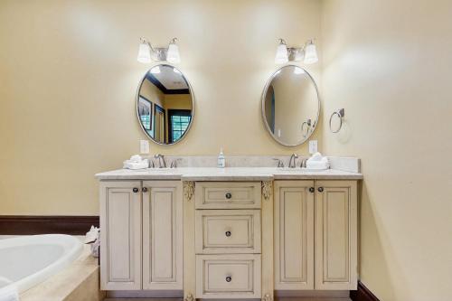 a bathroom with a sink and two mirrors at Key Quest in Marathon
