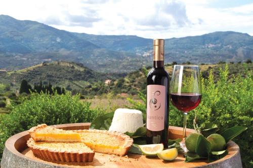 a bottle of wine and a plate of bread and a glass at Antica Tindari in Patti