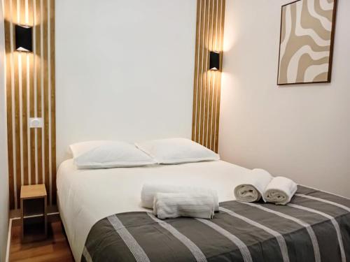 a bedroom with a bed with two towels on it at Stelina Haussmann - Balcony in Villeneuve-sur-Lot