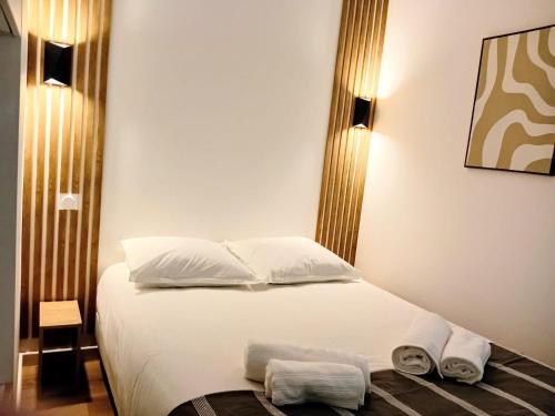 a bedroom with a bed with two towels on it at Stelina Haussmann - Balcony in Villeneuve-sur-Lot