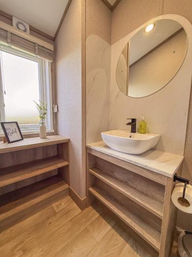 a bathroom with a sink and a mirror at Hornbeam Lodge in Bassenthwaite