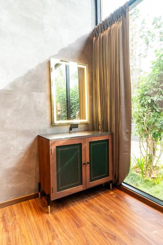 a television in a room with a mirror and a window at Forrest in Mahabalipuram