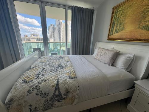 1 dormitorio con 1 cama y vistas a la torre Eiffel en Family Stay Ocean Reserve Resort Sunny Isles, en Sunny Isles Beach