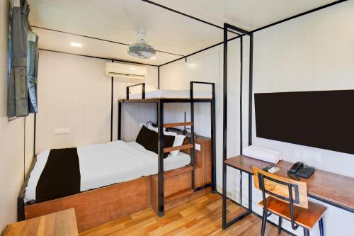 a bedroom with a bed and a desk and a tv at Hotel O Citrus Resort in Āmbavna