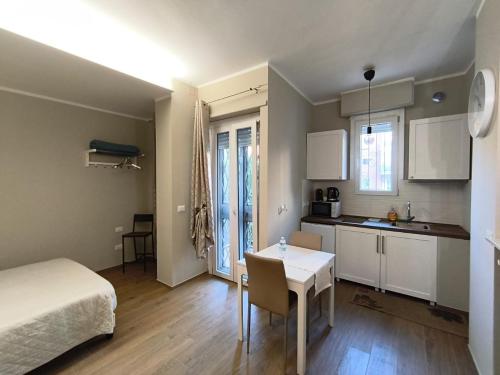 a room with a bed and a table and a kitchen at Casa Piera in Turin