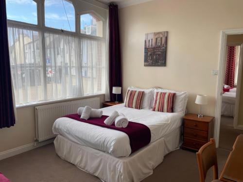 ein Schlafzimmer mit einem großen Bett mit weißen Laken und Kissen in der Unterkunft Mutiny House in Weymouth