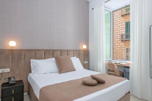 a bedroom with a bed with two pillows on it at Hotel Odeon Napoli in Naples