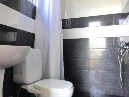 a bathroom with a white toilet and a sink at 15 Kviparosi Guest House in Makhinjauri