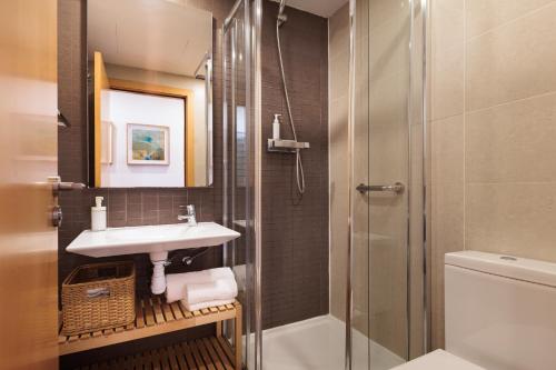 un baño con lavabo y ducha en Mar Bella Beach Apartments, en Barcelona