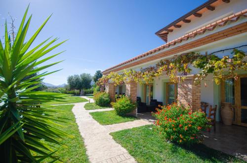 a house with a garden and a pathway at HOTEL Essenza di Mirto in La Caletta