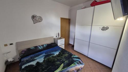 a bedroom with a bed and a refrigerator at Roccolo apartment in Pieve di Cadore