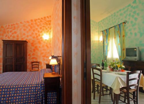 une chambre avec un lit et une table et une salle à manger dans l'établissement Hotel Residence I Briganti di Capalbio, à Capalbio