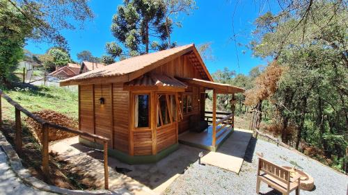 a small wooden house with a bench next to it at Folk Cabin in Monte Verde