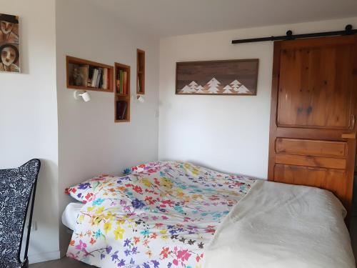 Un dormitorio con una cama con un edredón colorido. en Sorbier Des Oiseaux, en Font-Romeu
