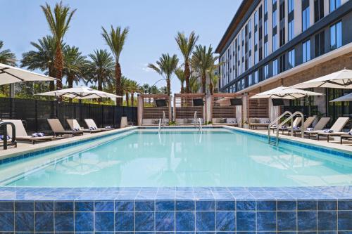 a swimming pool at a hotel with chairs and a building at AC Hotel Las Vegas Symphony Park in Las Vegas