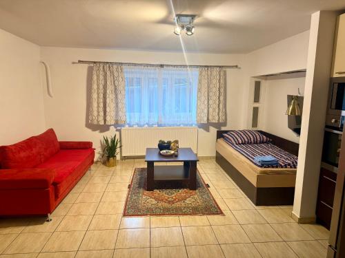 a living room with a red couch and a bed at Mieszkanie dwuosobowe in Tarnów