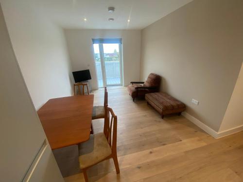 a living room with a table and a couch at One Bedroom Apartment With Large Balcony in Swanley Junction