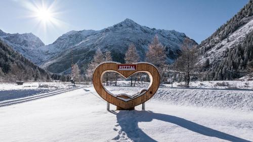 un panneau en forme de cœur au milieu d'une route enneigée dans l'établissement Haus Bergheim, à Sankt Leonhard im Pitztal